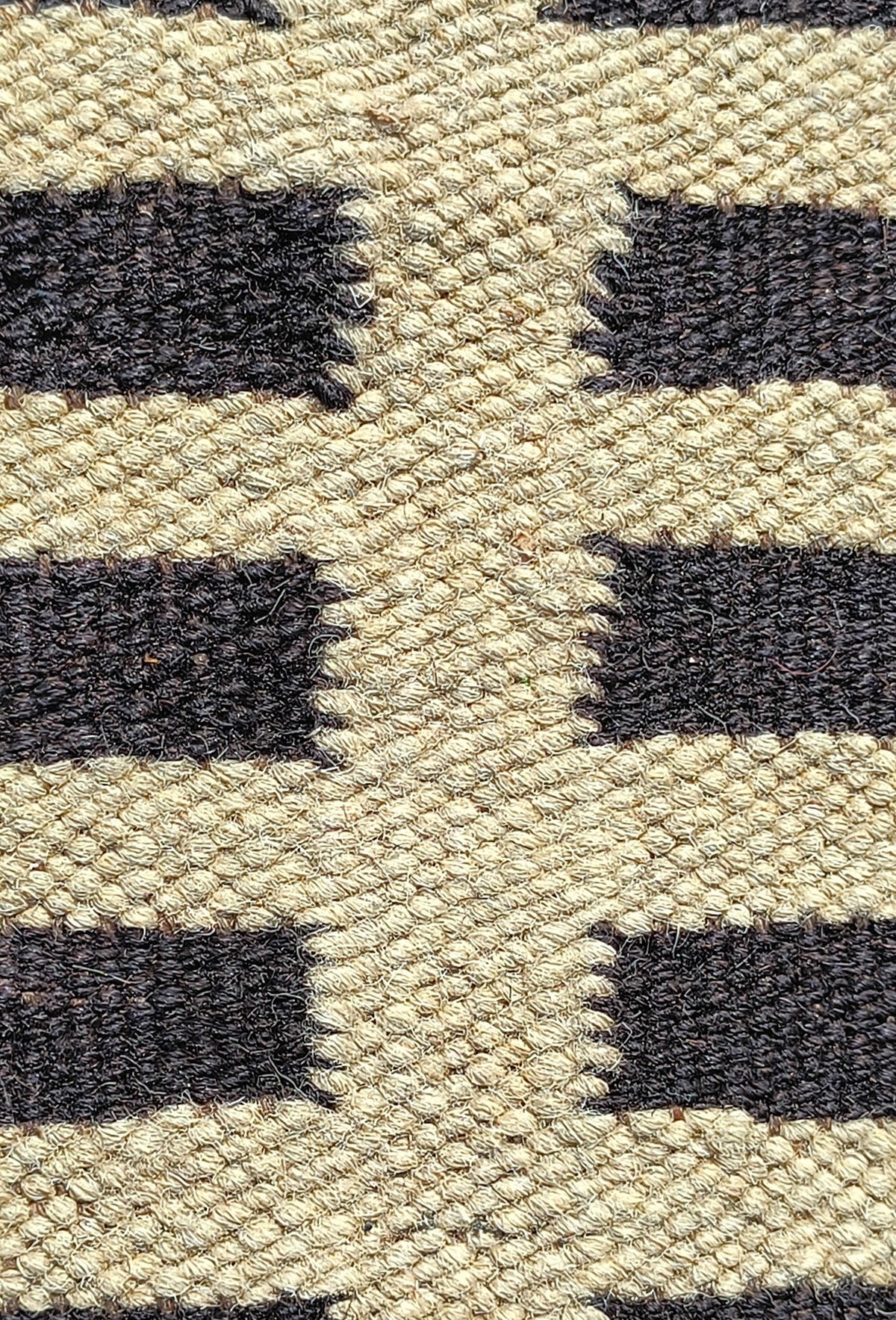 Detalle de motivos geométricos lineales en alfombra Kelim de lana