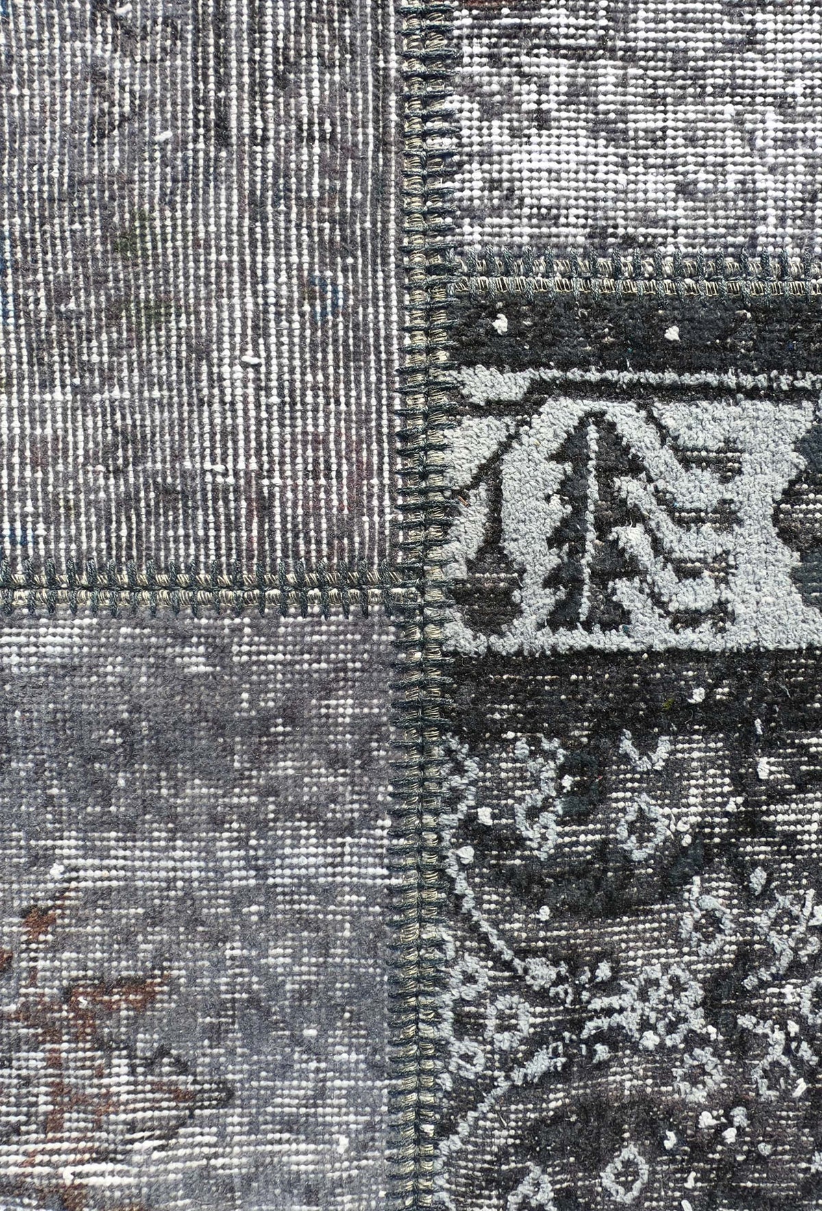 Fragmentos de alfombras persas antiguas unidas en patrón patchwork artesanal
