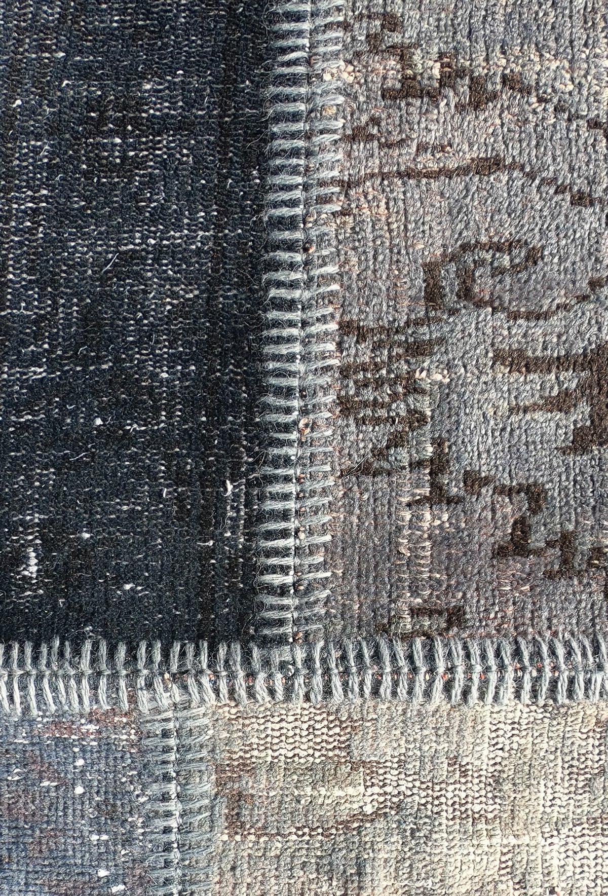 Detalle de fragmentos de alfombra persa antigua unidos en diseño patchwork artesanal