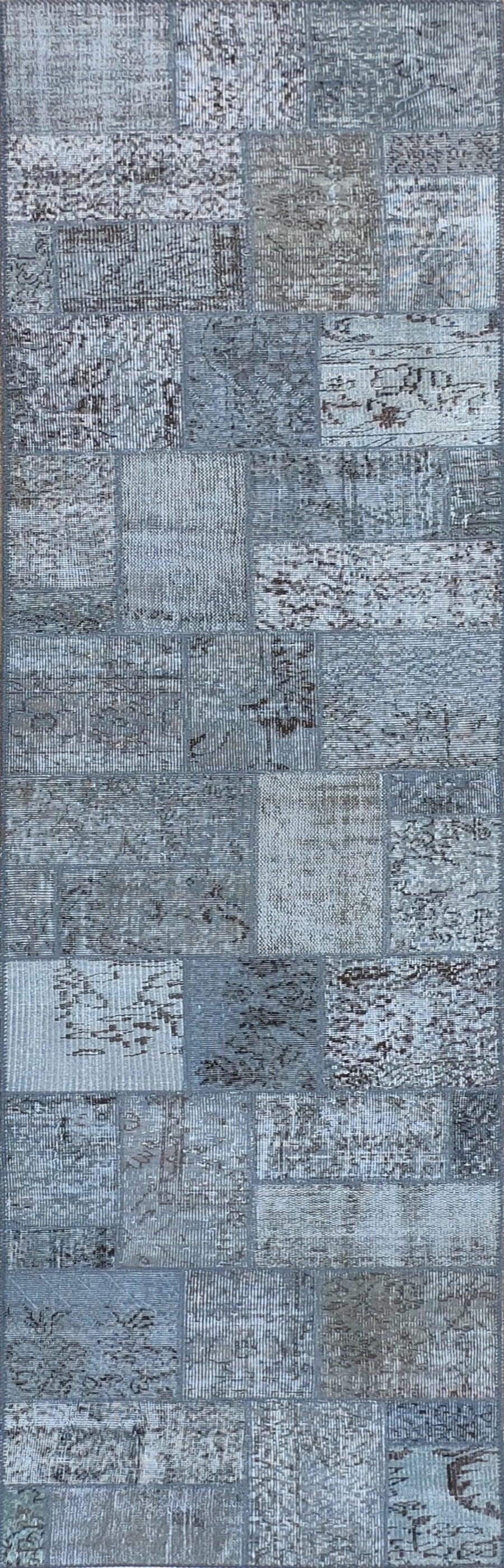 Detalle de fragmentos de alfombra persa antigua unidos en diseño patchwork artesanal
