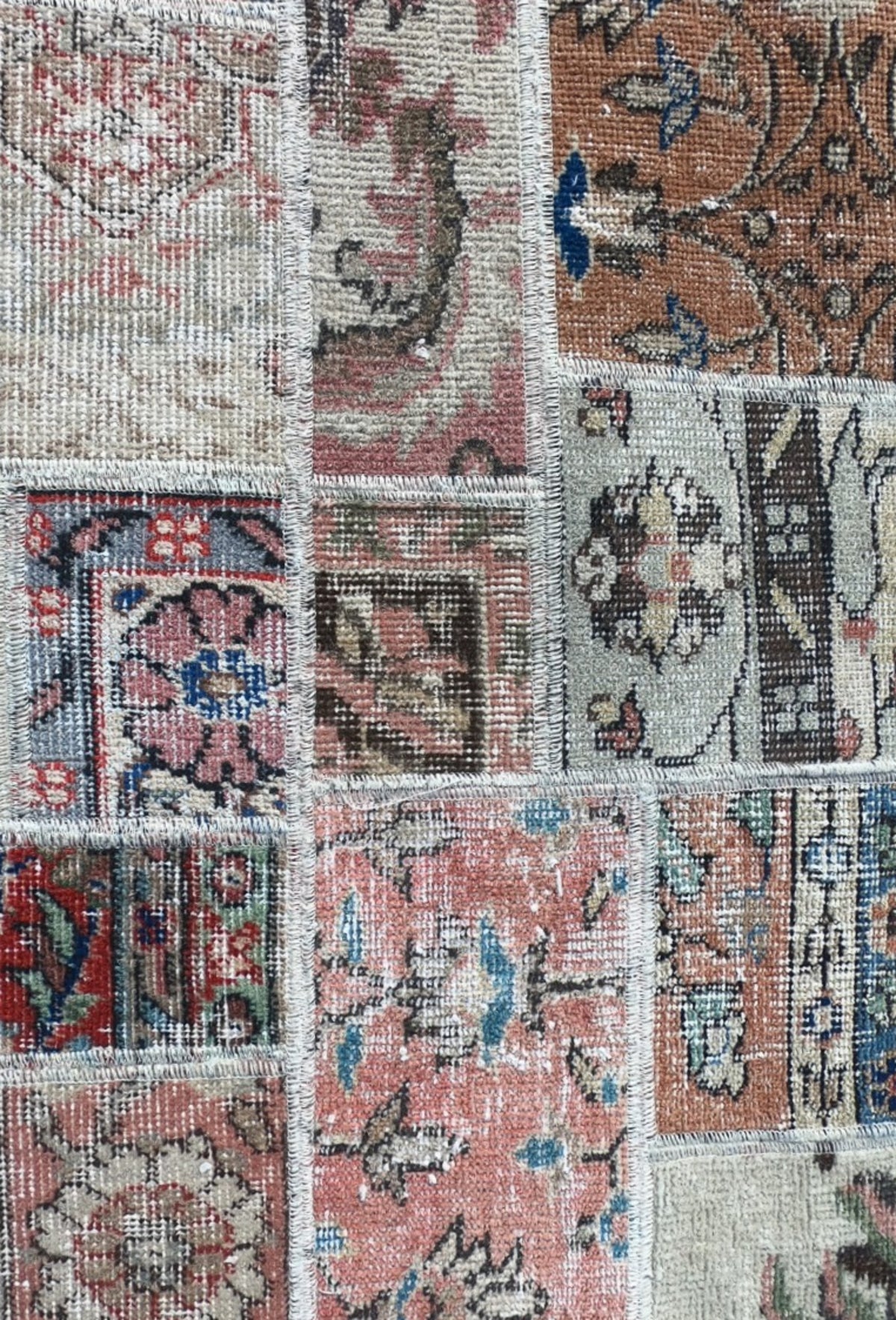 Fragmentos de alfombras persas antiguas unidas en patrón patchwork artesanal