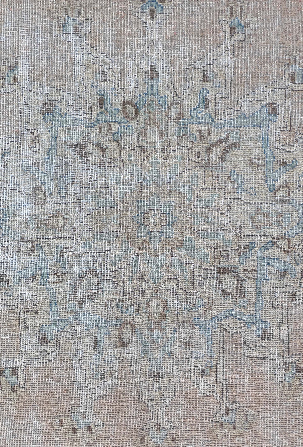 Detalle de diseño desgastado intencionalmente en alfombra iraní de lana