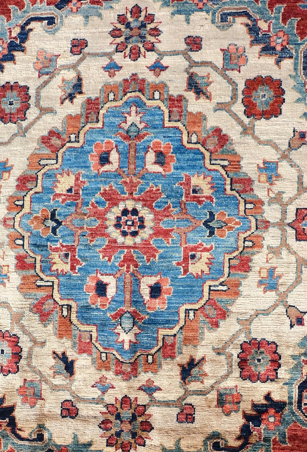 Detalle de grecas y diseño floral en alfombra persa de lana hecha a mano