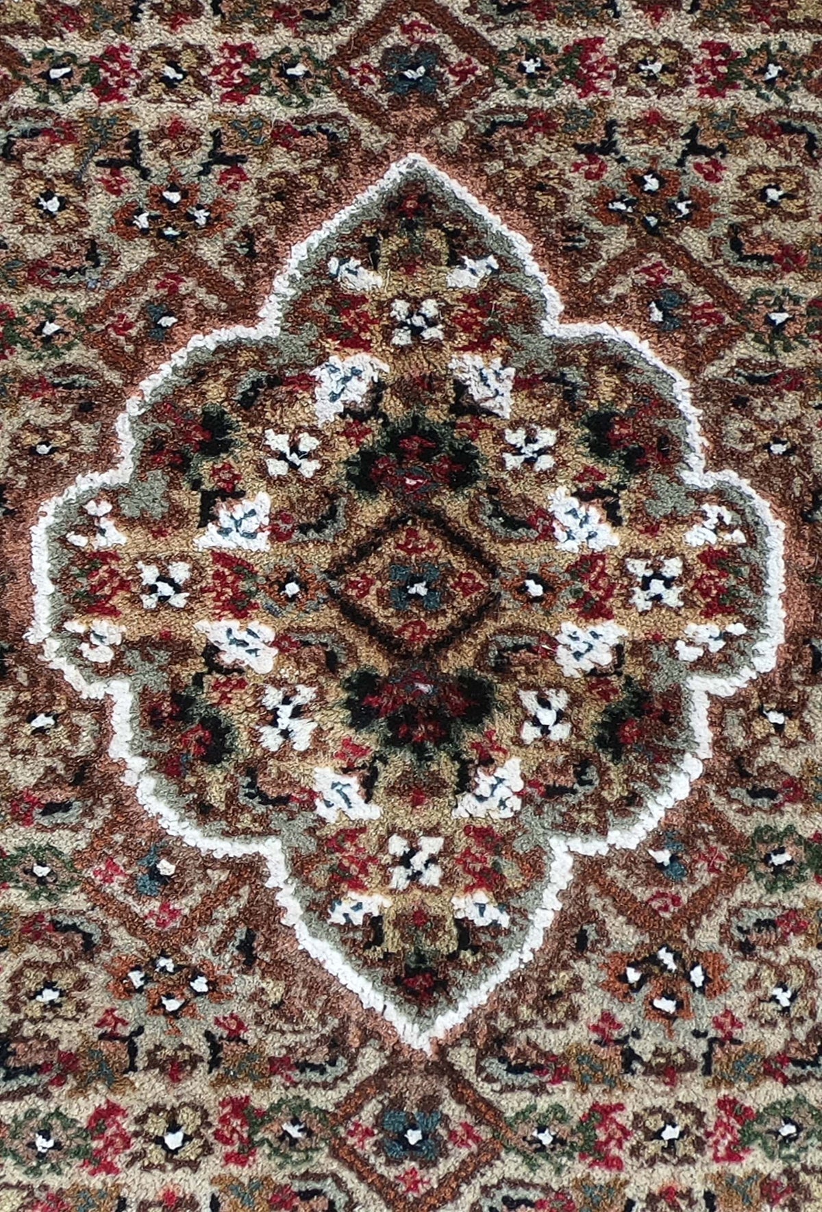 Detalle del medallón central en alfombra persa de lana y seda artesanal