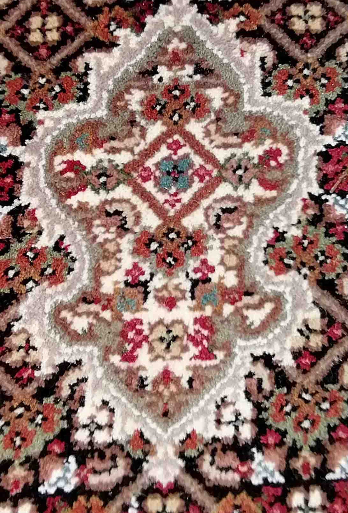 Detalle medallón central y bordes en alfombra persa decorativa de lana